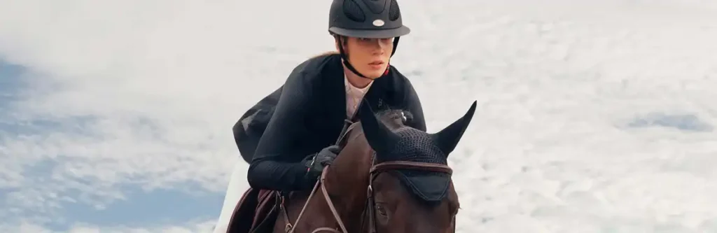 Cavalière franchissant un obstacle avec son cheval pendant une compétition